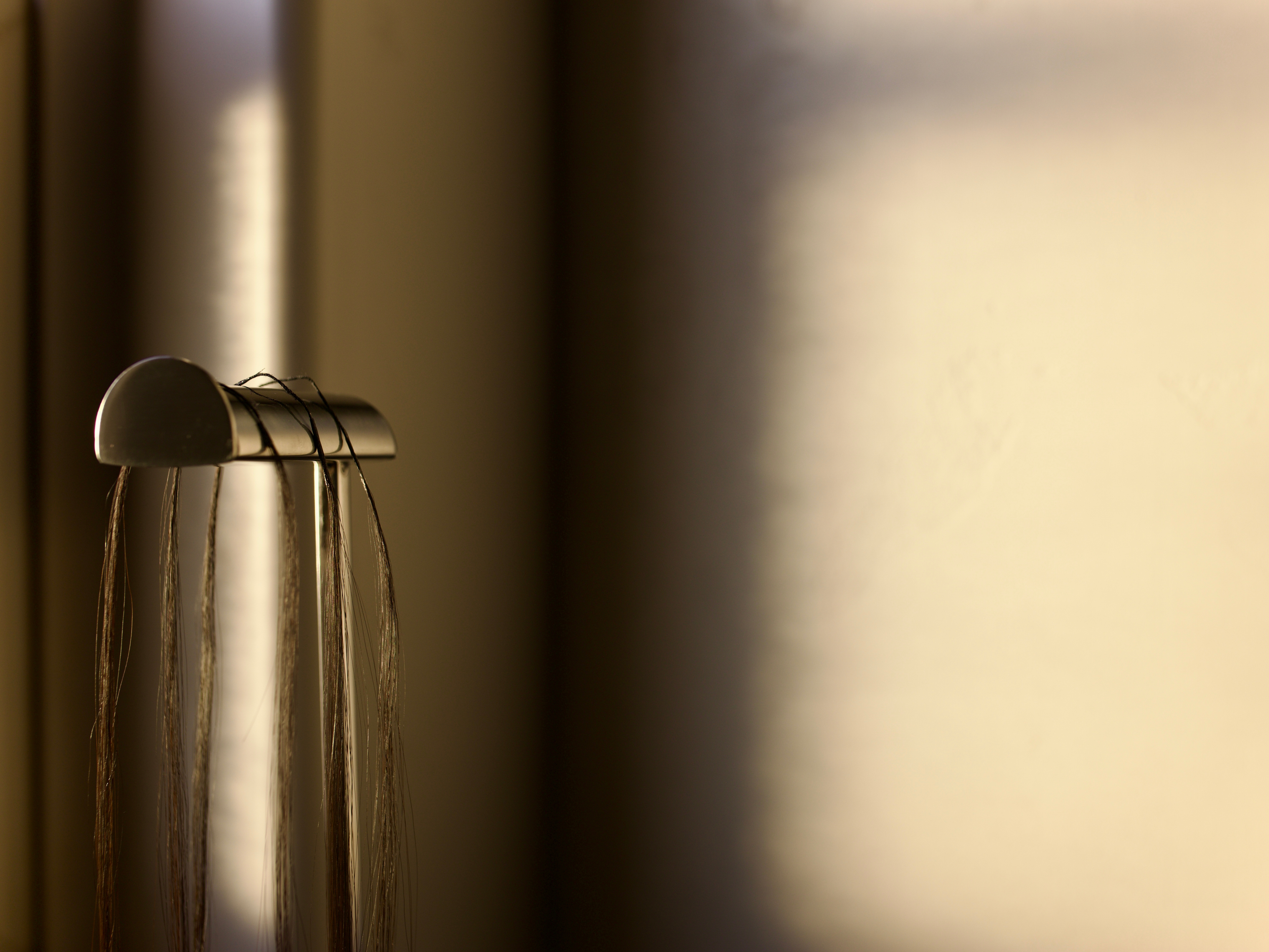 3 straight crochet strands displayed on a metallic object with a blurred background